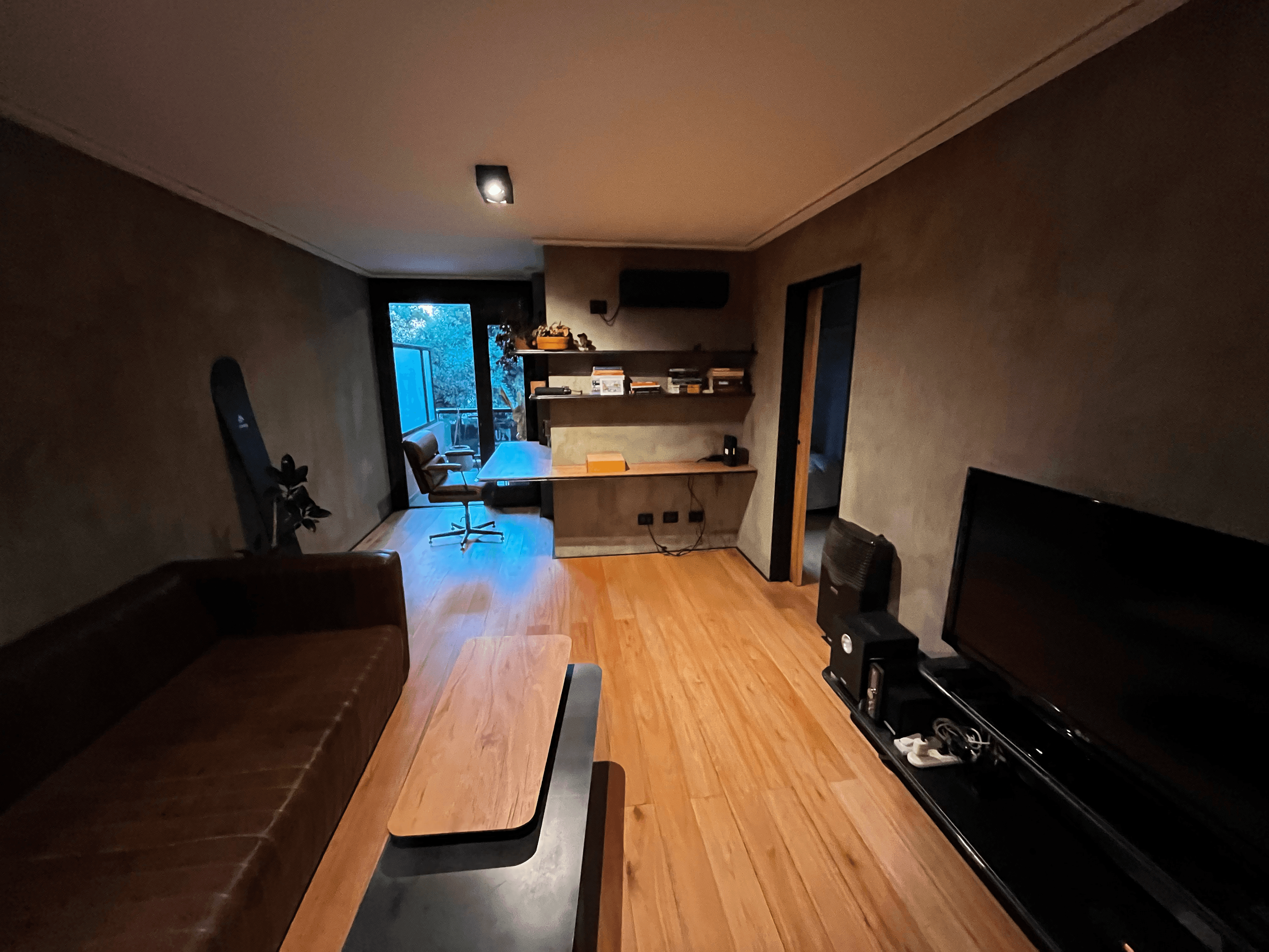 Living amplio con TV y zona de trabajo al fondo