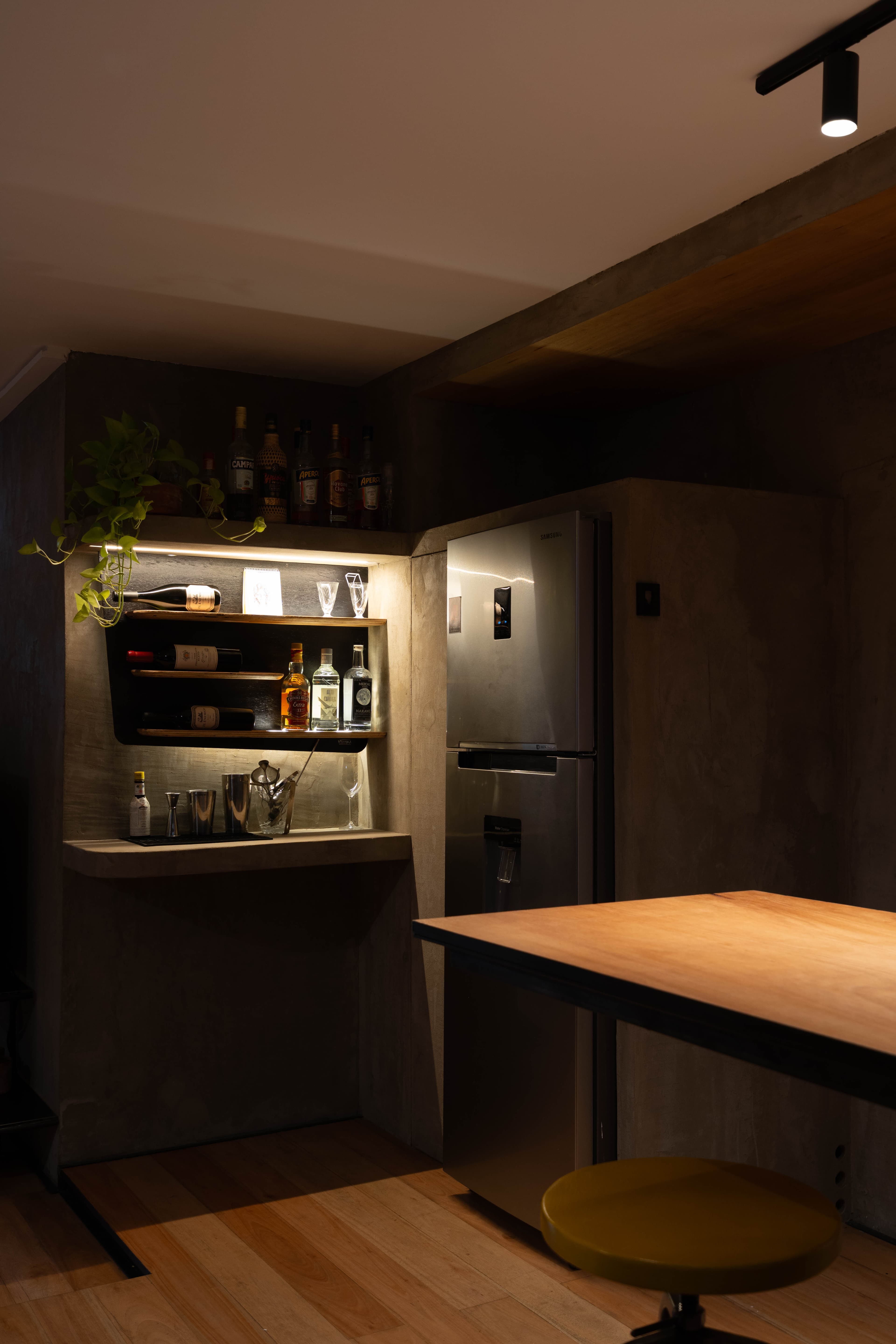 Heladera y zona de coctelería con barra y banco